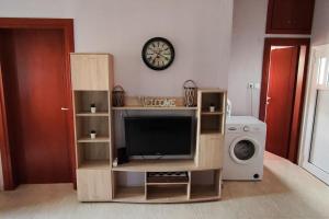 a living room with a tv and a clock on the wall at Heaven House in Sozopoli