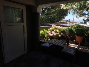 a porch with a door and a bench and flowers at Apartment Melany in Senj