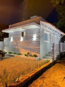 una pequeña casa con porche por la noche en Hospedagem Pierina, en Gramado