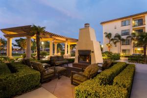 eine Terrasse mit einem Kamin und Stühlen sowie ein Gebäude in der Unterkunft Homewood Suites by Hilton San Diego Airport-Liberty Station in San Diego