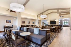 un restaurante con sofá, mesas y sillas en Homewood Suites by Hilton San Diego Airport-Liberty Station, en San Diego