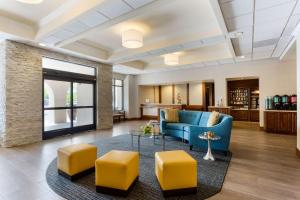 a living room with a blue couch and yellow stools at Homewood Suites by Hilton San Diego Airport-Liberty Station in San Diego