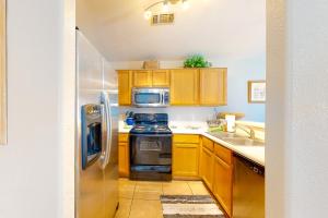 eine Küche mit Holzschränken und einem Kühlschrank aus Edelstahl in der Unterkunft Cactus Casita in Chandler