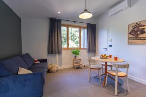 a living room with a blue couch and a table at Hôtel - Lodges de Lemptégy in Saint-Ours