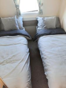 2 camas sentadas junto a una ventana en una habitación en Blue Dolphin Holiday Park, en Gristhorpe