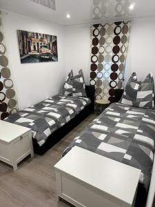 ein Schlafzimmer mit 2 Betten und einem Tisch darin in der Unterkunft 2 Ferienwohnungen in einem Haus mit EBK, WLAN, SELF-CHECK-IN in Ittlingen
