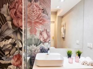 uma casa de banho com um lavatório e um mural de flores em Villa Neptun - PREMIUM APARTMENTS em Gdansk