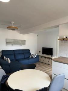 een woonkamer met een blauwe bank en een tafel bij Apartamento a 20 m de playa Almería in Almería