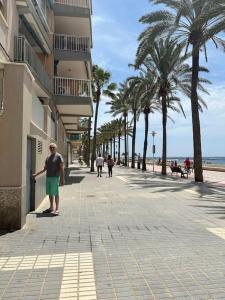 een man op een stoep naast een strand bij Apartamento a 20 m de playa Almería in Almería
