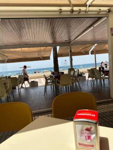 een restaurant met uitzicht op het strand met tafels en stoelen bij Apartamento a 20 m de playa Almería in Almería