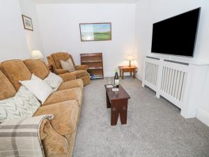 a living room with a couch and a flat screen tv at Nook Farm Holiday Cottage in Sheffield