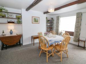Nook Farm Holiday Cottage في شيفيلد: غرفة طعام مع طاولة وكراسي ومكتب