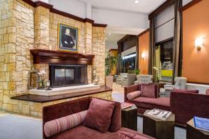 The Emily Morgan Hotel - A DoubleTree by Hilton في سان انطونيو: غرفة معيشة مع موقد حجري وأرائك