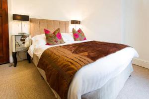 セント・オーステルにあるWheel Water Apartmentのピンクの枕が付く大きなベッドが備わるホテルルームです。
