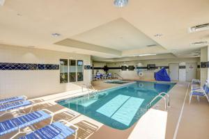 una gran piscina con sillas azules en una habitación en Hampton Inn & Suites Savannah - I-95 South - Gateway, en Savannah