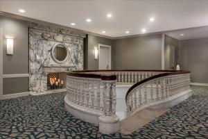 a lobby with a staircase and a fireplace at Wellsworth Hotel in Southbridge
