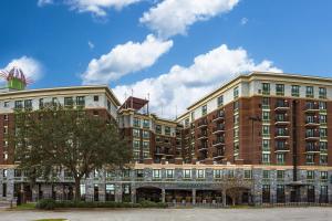 um grande edifício de tijolos com uma árvore em frente em Homewood Suites Savannah Historic District/Riverfront em Savannah