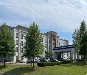 a hotel with cars parked in front of it at Hampton Inn & Suites Louisville East in Louisville