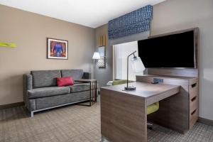 a living room with a couch and a flat screen tv at Hampton Inn & Suites Louisville East in Louisville