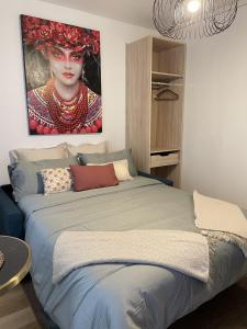 a bedroom with a bed with a painting of a woman at joli studio paris 16 Victor Hugo in Paris