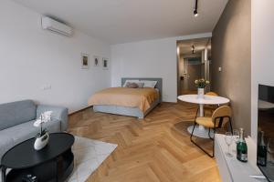 a living room with a bed and a couch and a table at Cherry Apartment in Bratislava