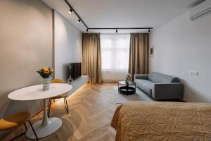 um quarto com uma cama, uma mesa e um sofá em Cherry Apartment em Bratislava