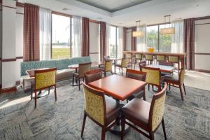 路易維爾的住宿－路易斯維爾東北漢普頓酒店，用餐室设有桌椅和窗户。