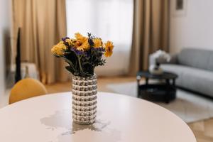 a vase filled with yellow and purple flowers on a table at Cherry Apartment in Bratislava