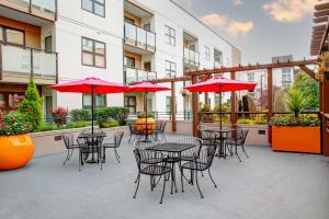 eine Terrasse mit Tischen, Stühlen und roten Sonnenschirmen in der Unterkunft Hampton Inn & Suites Seattle-Downtown in Seattle