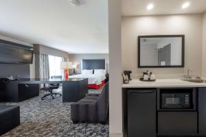 a hotel room with a bed and a desk with a sink at Hampton Inn & Suites DuPont in DuPont