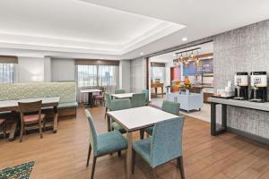 a restaurant with tables and chairs and a kitchen at Hampton Inn Seekonk in Seekonk