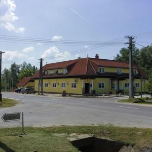 una casa amarilla con techo rojo en una calle en Malom Fogadó, en Balatonboglár