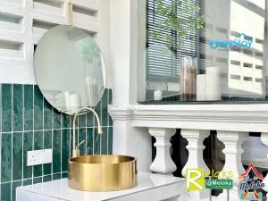 a gold bucket on a counter next to a mirror at JonkerHeritage House WalkingDistance10minsJonker By Heystay Management in Melaka