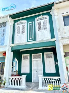 une maison verte et blanche avec des fenêtres blanches dans l'établissement JonkerHeritage House WalkingDistance10minsJonker By Heystay Management, à Malacca
