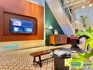 a lobby with a table and a tv on a wall at JonkerHeritage House WalkingDistance10minsJonker By Heystay Management in Melaka