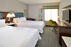 Habitación de hotel con 2 camas y TV de pantalla plana. en Hampton Inn San Francisco - Daly City, en Daly City