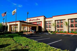 un hôtel avec drapeaux en face d'un parking dans l'établissement Hampton Inn Fremont, à Fremont