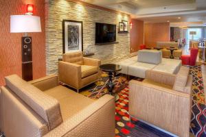 a hotel lobby with couches and chairs and a television at Hampton Inn Fremont in Fremont