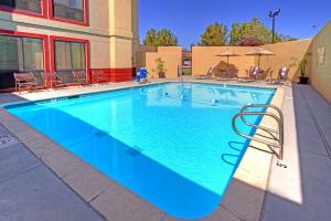 una gran piscina azul con sillas y sombrillas en Hampton Inn Fremont, en Fremont