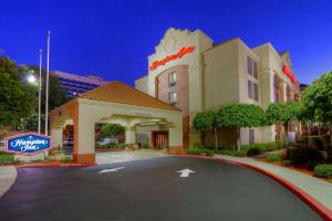 um edifício de hotel com uma placa em frente em Hampton Inn Milpitas em Milpitas