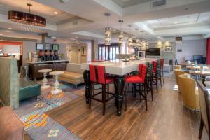 a restaurant with a bar with red chairs at Hampton Inn Milpitas in Milpitas
