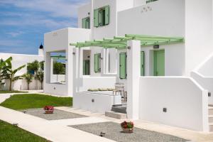 biały dom z zielonymi drzwiami i oknami w obiekcie Agalipa w mieście Skiros