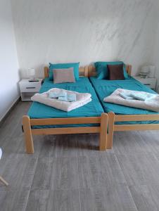 a bedroom with two beds with blue sheets at Vila Milica in Kladovo