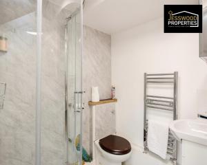 uma casa de banho com um chuveiro, um WC e um lavatório. em Bright and Cosy Studio Apartment by Jesswood Properties Short Lets With Free Parking Near M1 & Luton Airport em Luton