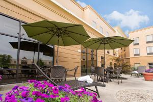 patio ze stołami i krzesłami, parasolami i kwiatami w obiekcie Hampton Inn & Suites Springboro w mieście Springboro