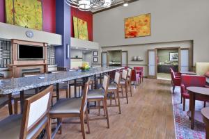 a large room with a long bar with chairs and tables at Hampton Inn & Suites Springboro in Springboro