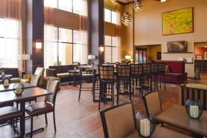 a restaurant with tables and chairs and a bar at Hampton Inn & Suites Springboro in Springboro