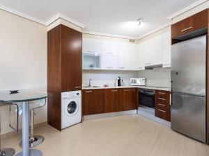 a kitchen with white cabinets and a washer and dryer at Live Vista Roja la Tejita in Granadilla de Abona