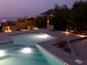 a swimming pool with lights in a backyard at night at Casa Miraflores in Cefalù