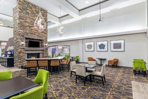 un vestíbulo con mesas, sillas y chimenea en Homewood Suites by Hilton Shreveport, en Shreveport